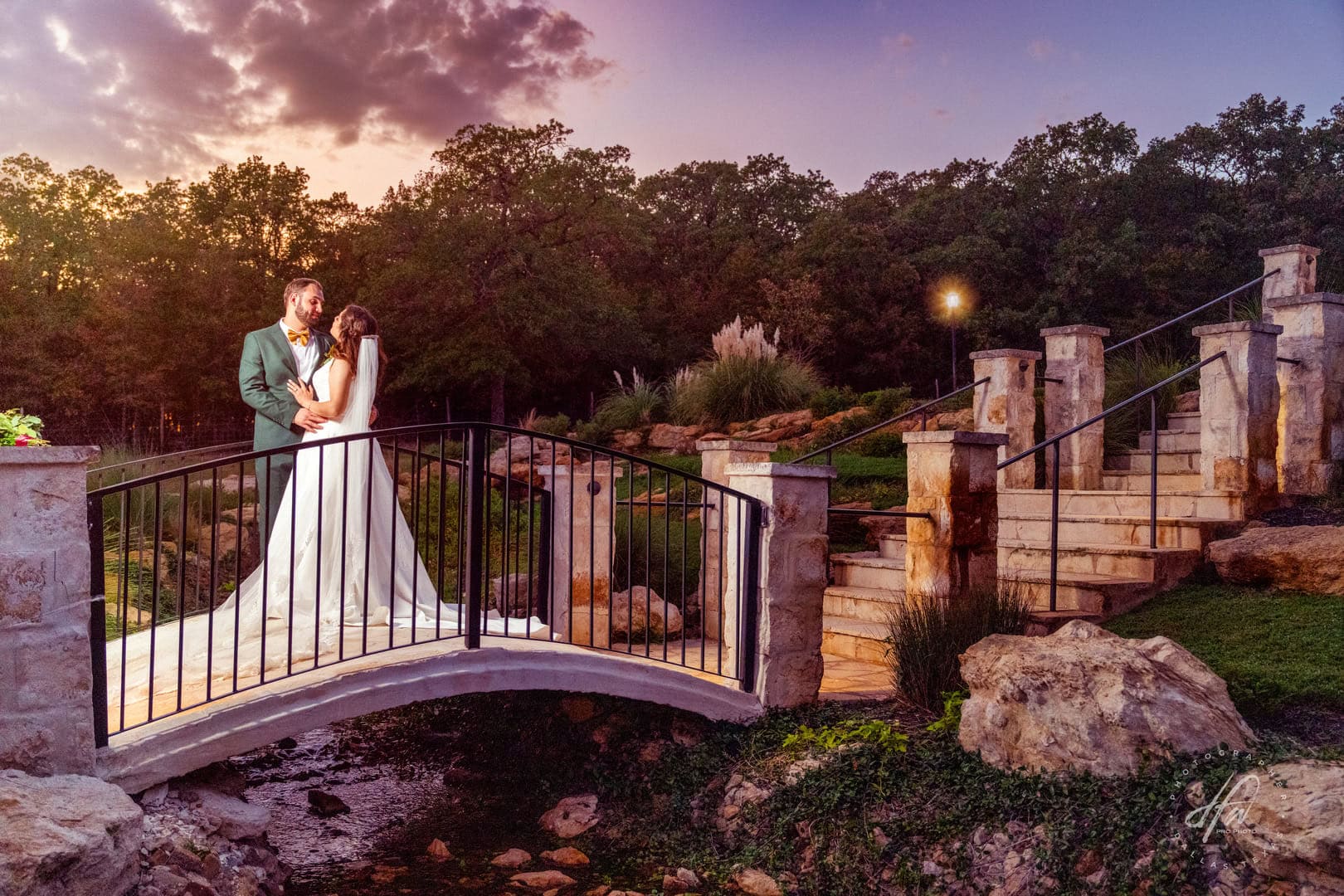 Bride and groom on a bridge during sunset.