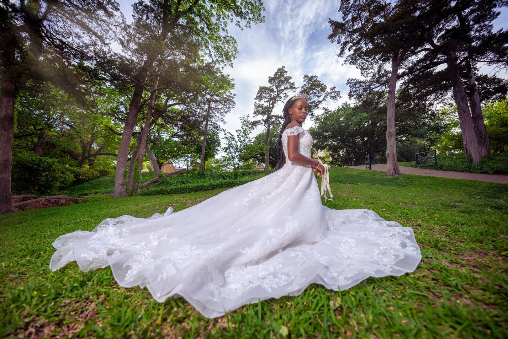 Bride poses for photo in dress outside.