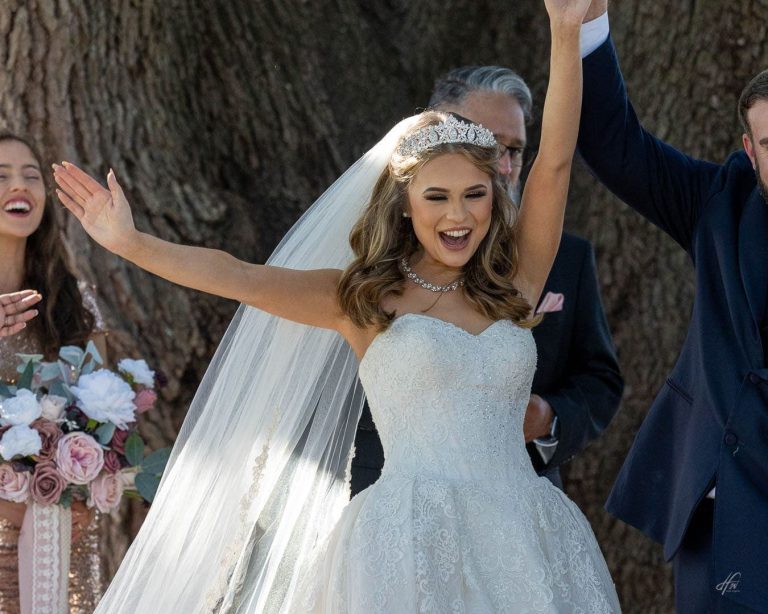 Bride with hands in the air after ceremony.