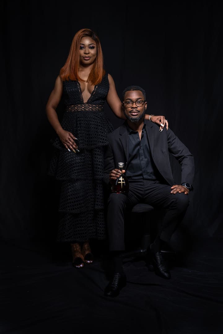 Couple posing for portrait in dark studio.