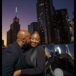 Couple in downtown. Man is kissing her cheek and she is smiling.