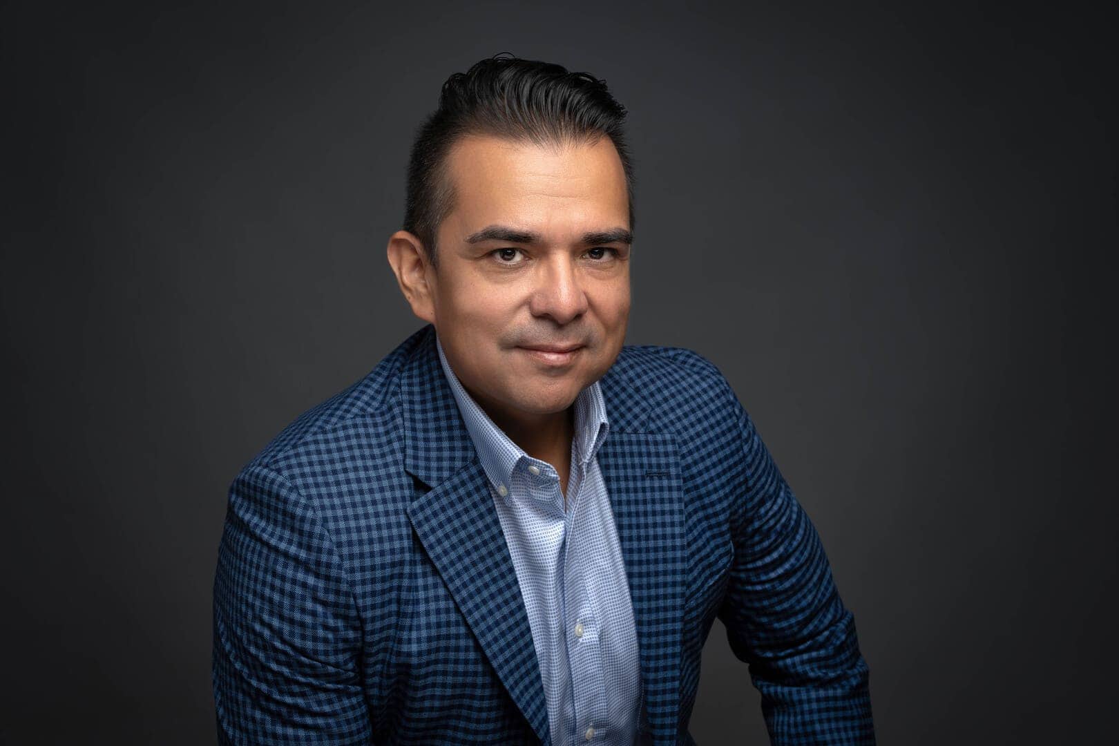 Headshot photography by Rick Porier. Man in blue checkered suit jacket and blue shirt posing for a headshot.