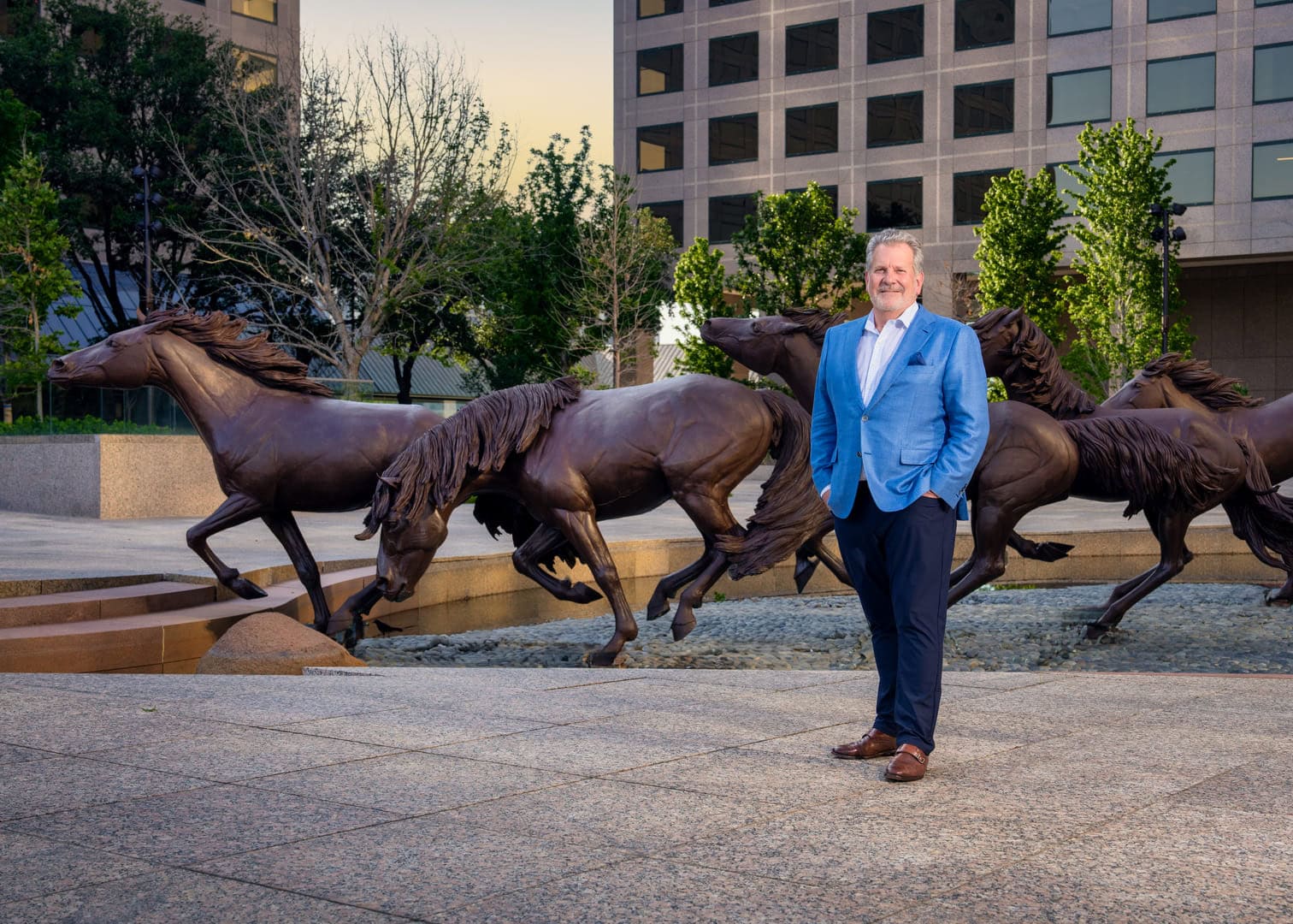 Man posing outside in front of buildings for executive portrait.