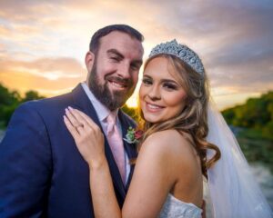 Newlyweds pose for portrait outside during twilight.