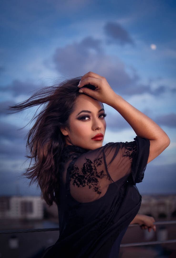 Girl posing for portrait outside during blue hour. Wind in hair.