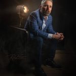 Man seated in chair posing for portrait.