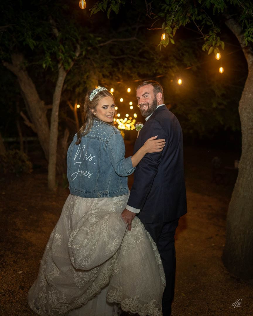 bride and groom at night walking down path.