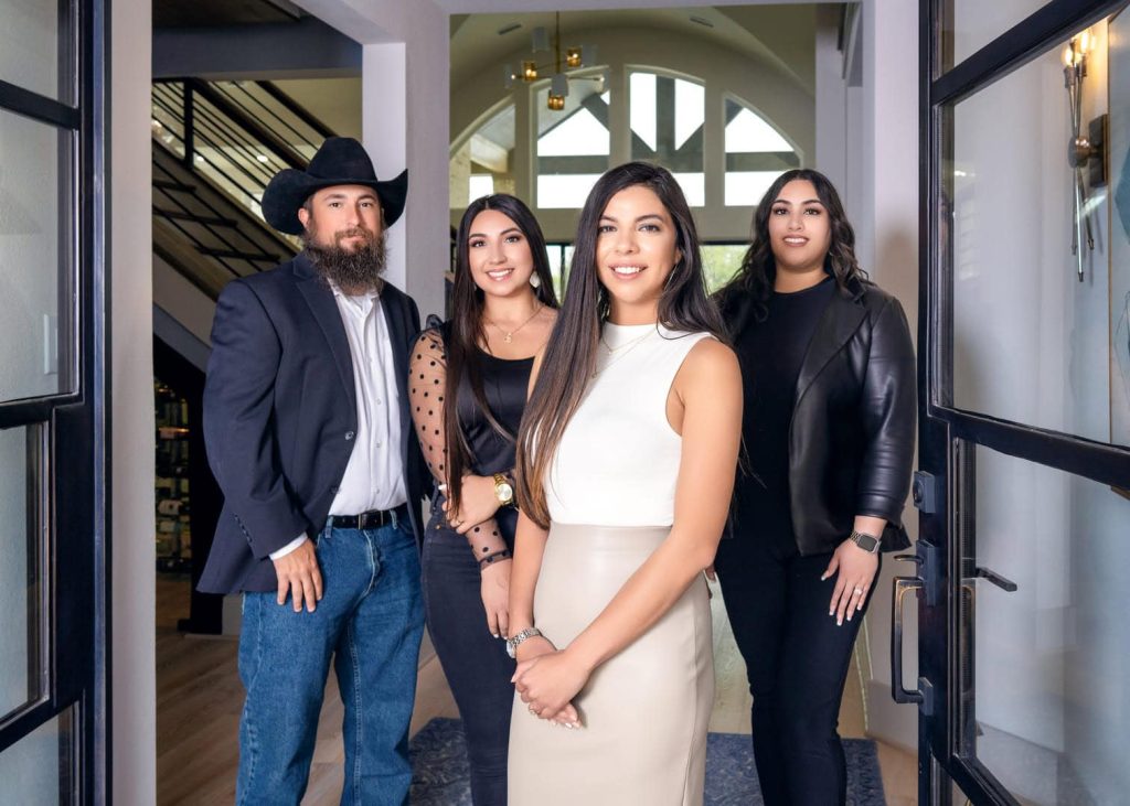 3 girls and 1 guy posing for photo inside home entryway.