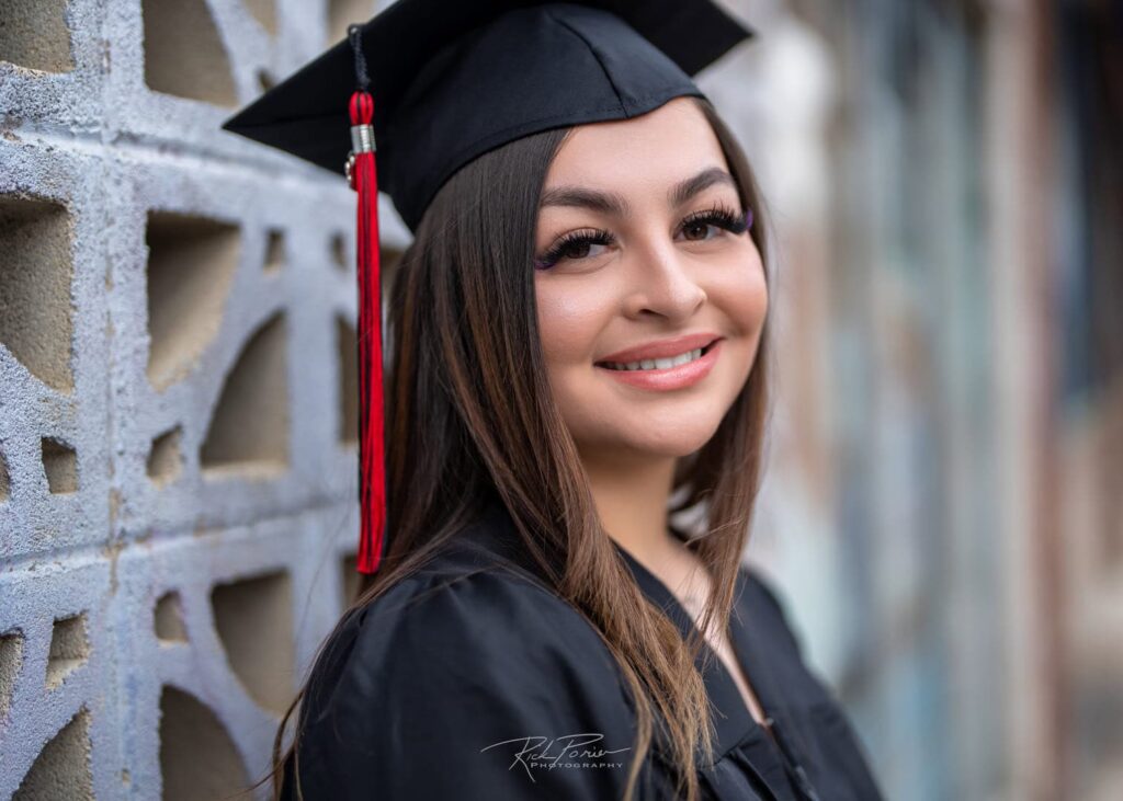 Girl poses for portrait. Wearing cap and gown.