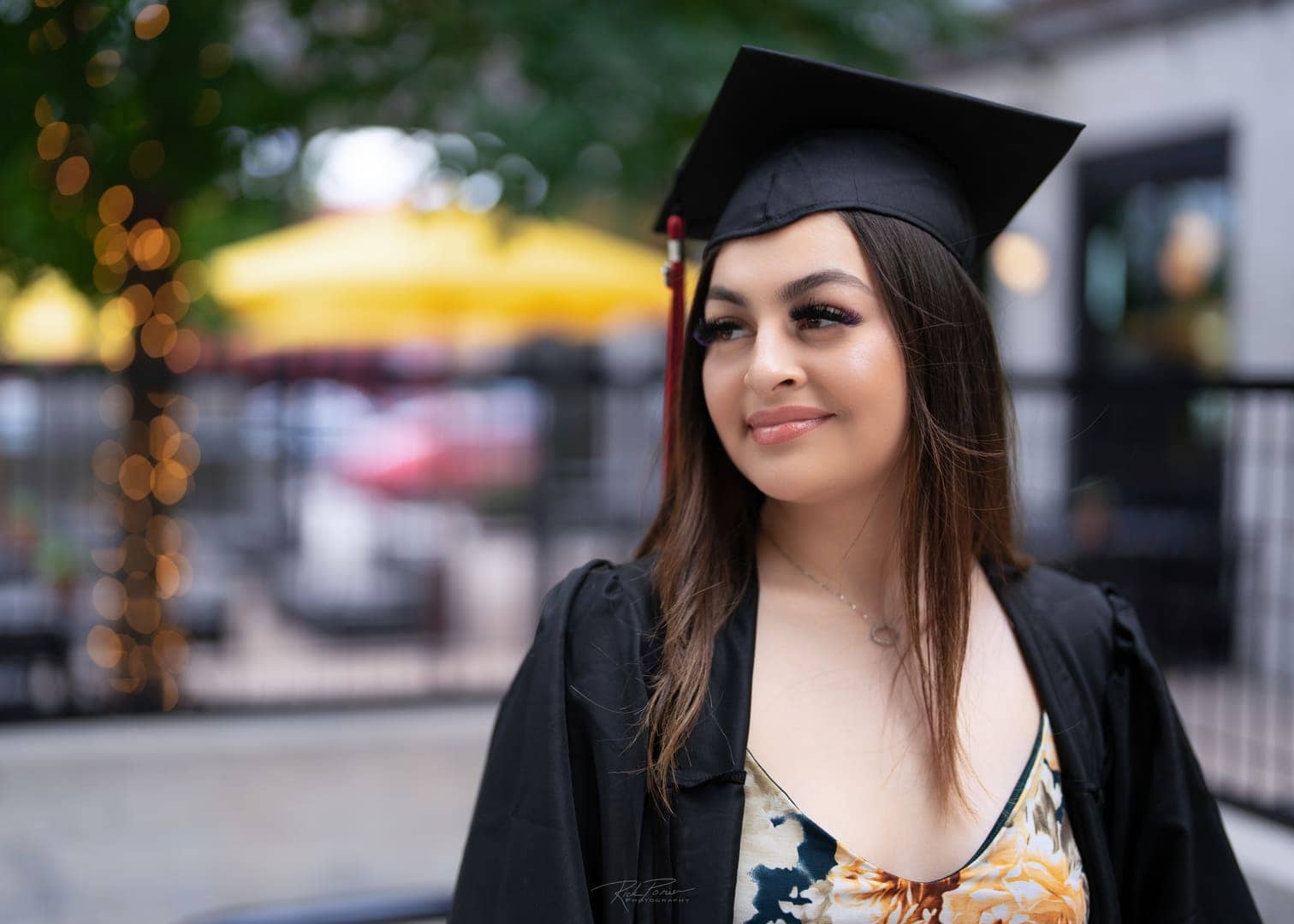 Girl poses for portrait. Wearing cap and gown.