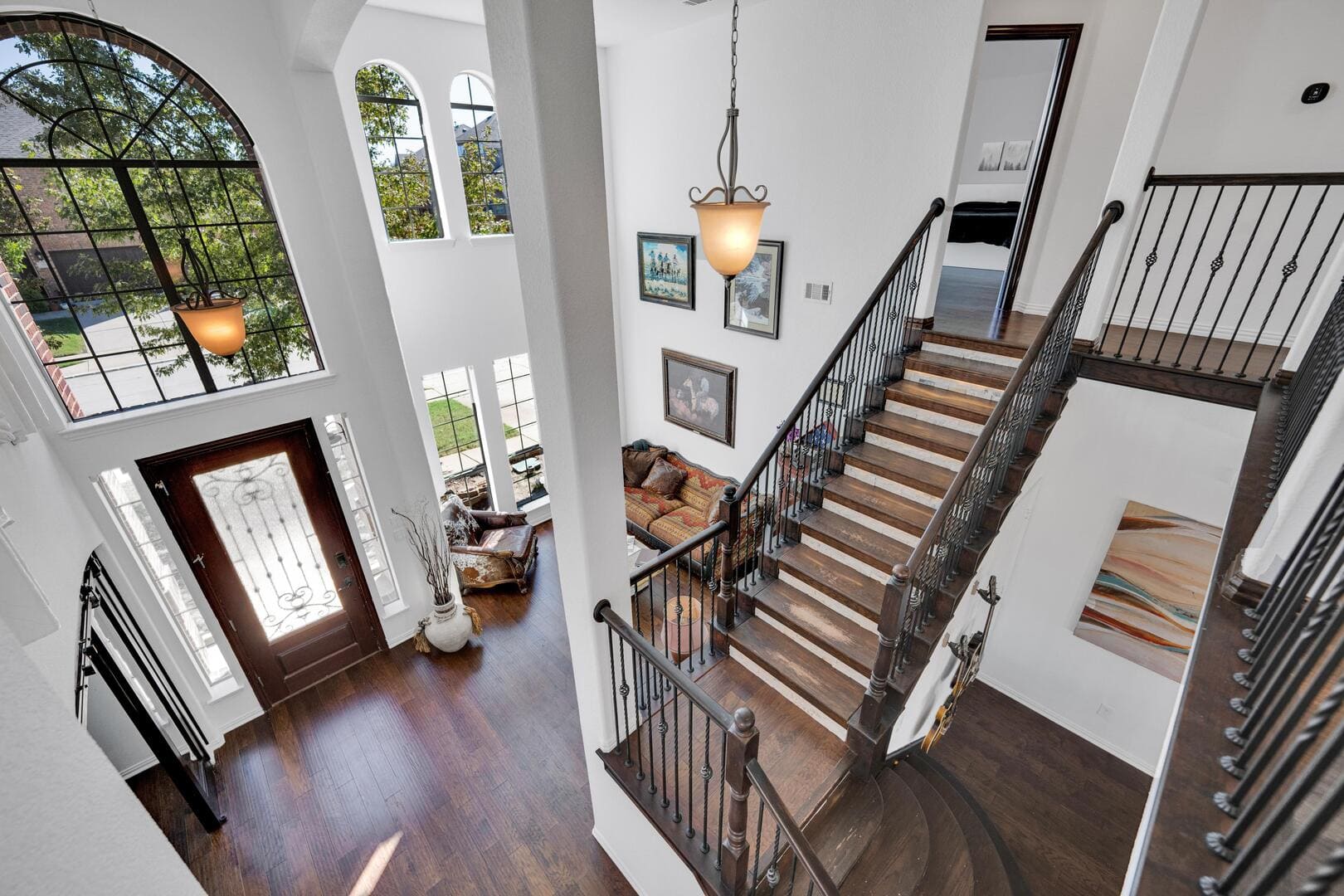 Looking over banister to downstairs in large home.