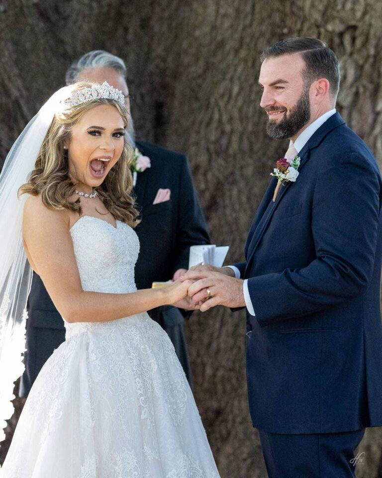 Bride is excited and groom looks on smiling.