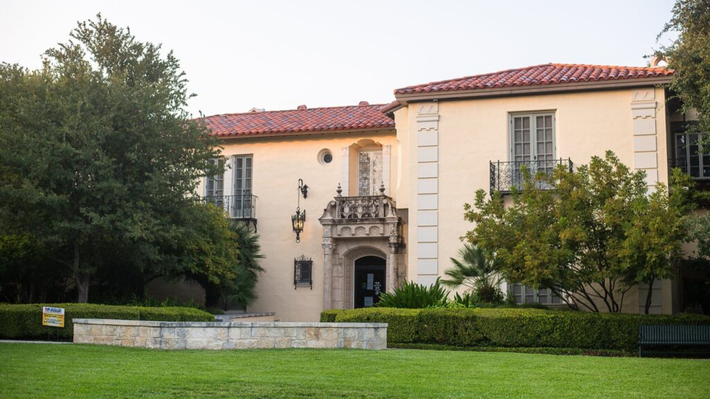A beautiful two-story stucco building with a red Spanish tile roof.