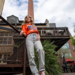 Pretty girl posing for a senior portrait in old industrial area that looks early 20th century.