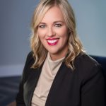 Lady with blonde hair posing for a business headshot.