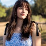 Senior portrait of a pretty girl with dark hair and blue eyes.