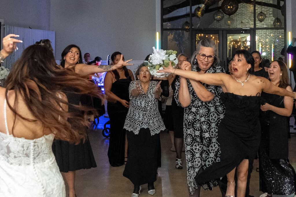 Bride throwing the bouquet to girls.