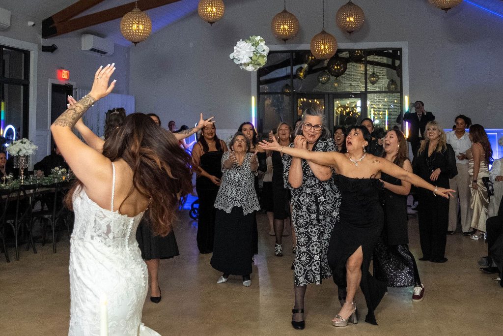 Bride throwing the bouquet to girls.