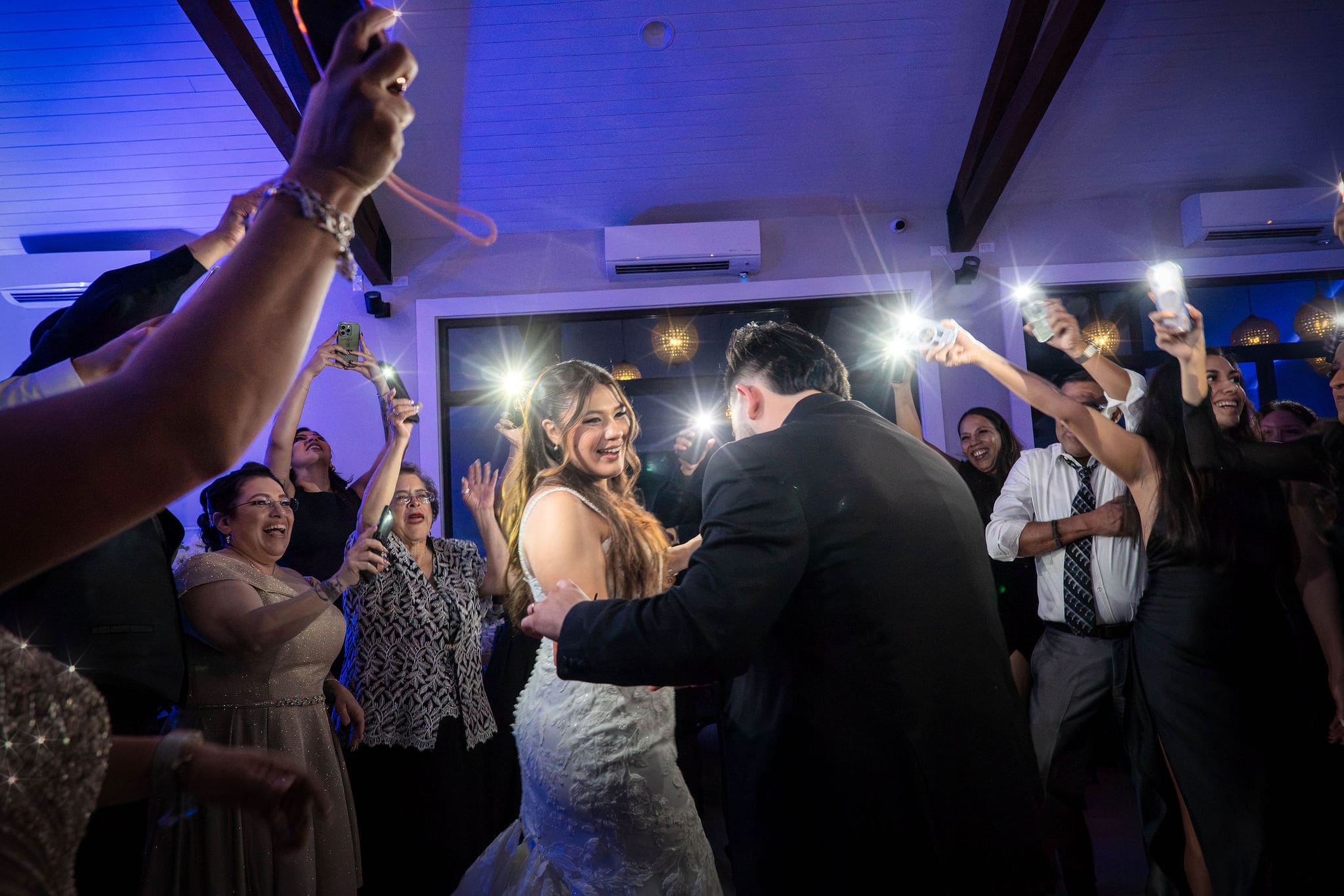 Wedding couple dancing in camera flashes