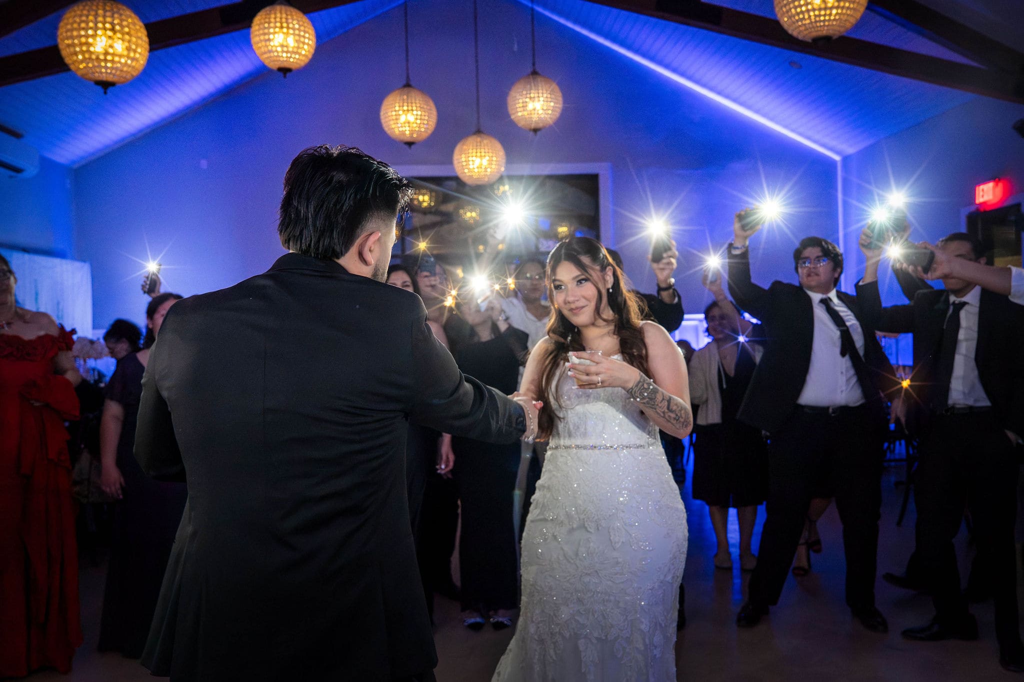 Wedding couple dancing in camera flashes.