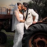 Wedding couple kissing and an old tractor