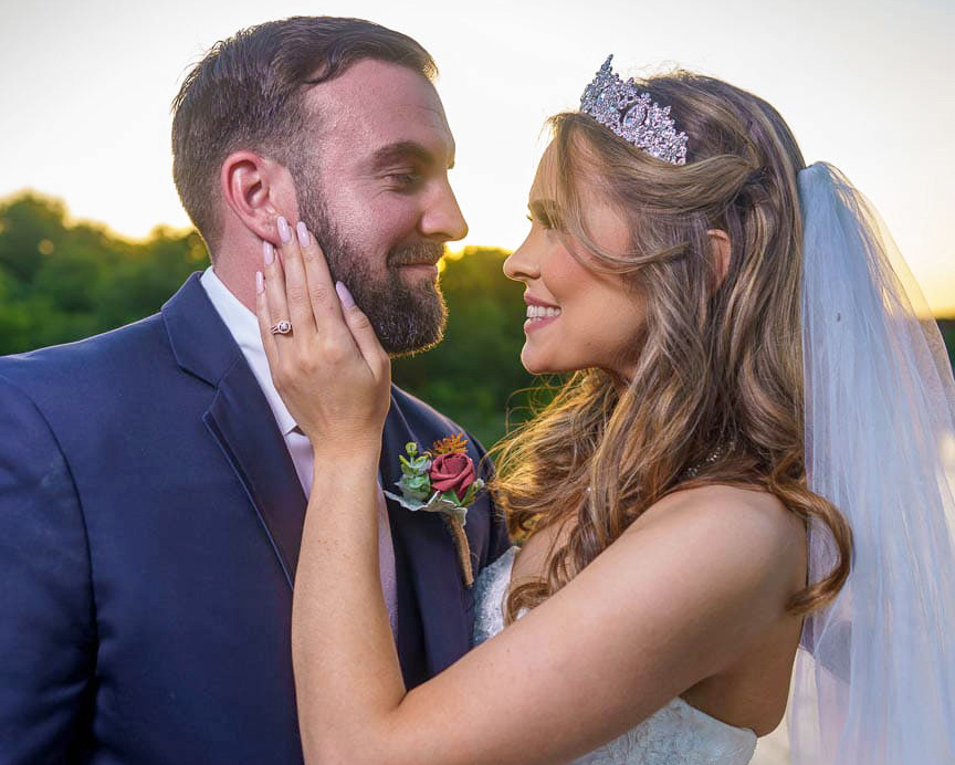 Bride and groom embrace at sunset.