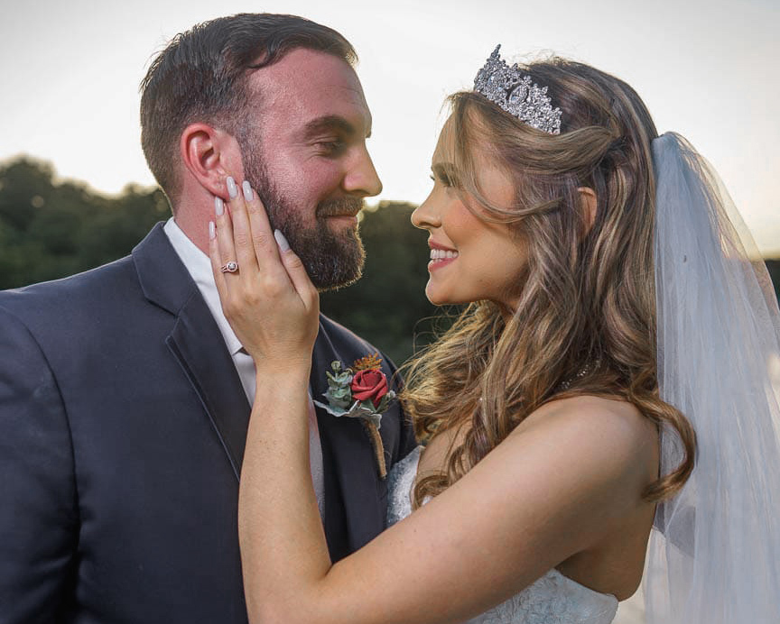 Bride and groom embrace at sunset.